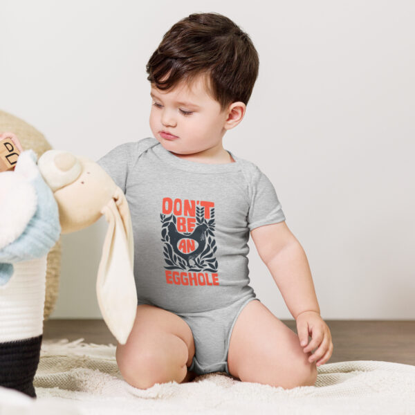 A baby sitting on the ground with a stuffed animal.