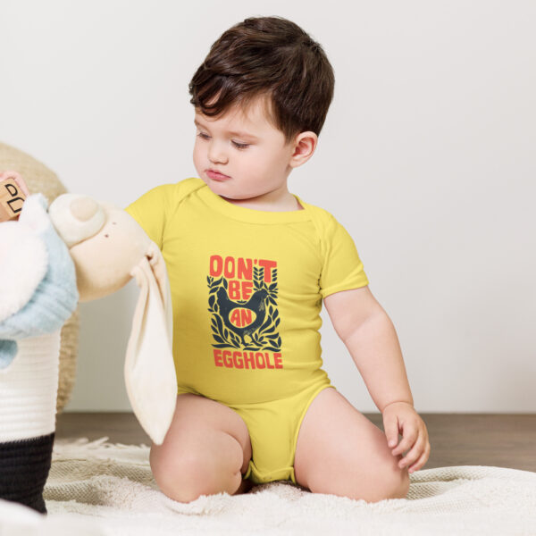 A baby sitting on the ground playing with a stuffed animal.