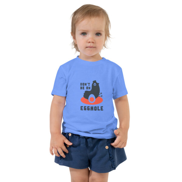 A toddler wearing blue shorts and a t-shirt.