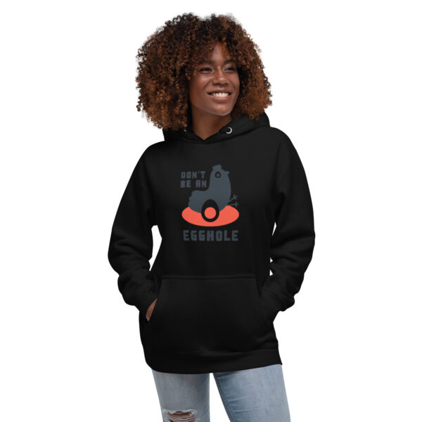 A woman wearing a black hoodie with an orange and red design.