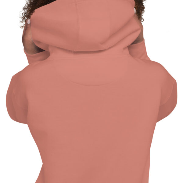 A person wearing a pink hoodie with a brown hair bun.