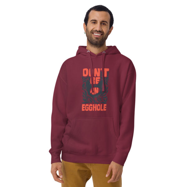 A man wearing a maroon hoodie with an orange design.