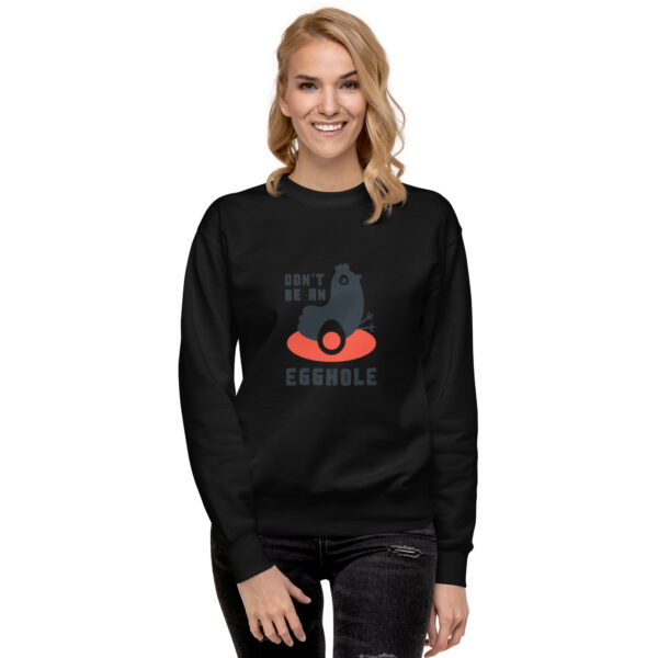 A woman wearing a black sweatshirt with an image of a cat on it.