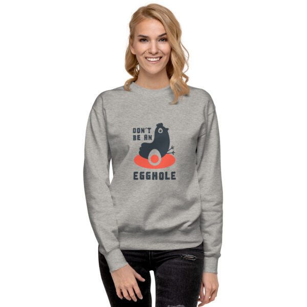 A woman wearing a gray sweatshirt with an image of a bear.