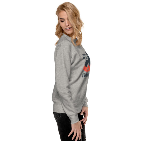 A woman wearing a gray sweatshirt with an image of a tree.