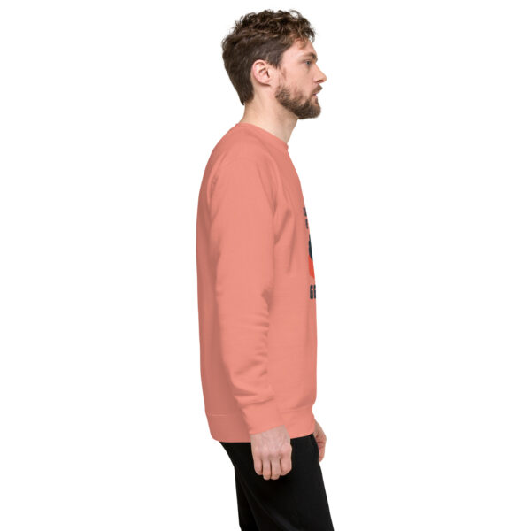 A man in a pink sweatshirt is standing up