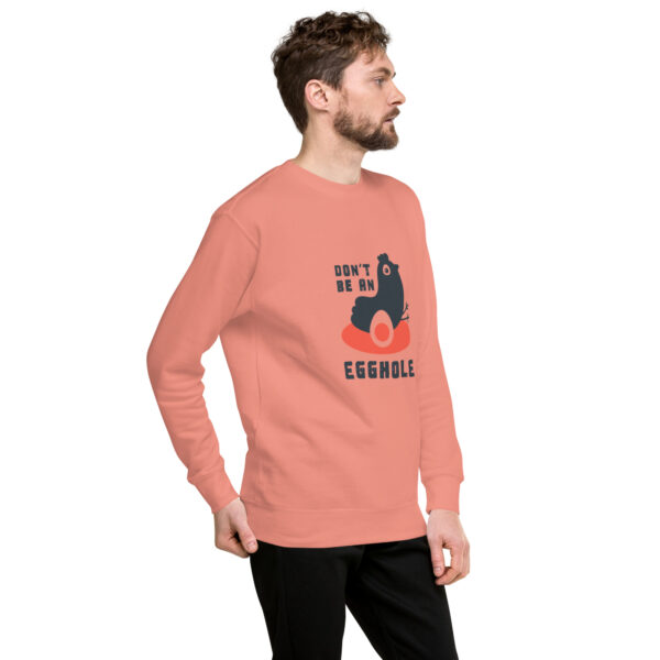 A man in black pants and an orange sweatshirt.