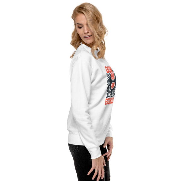 A woman wearing a white sweatshirt with an image of a person.