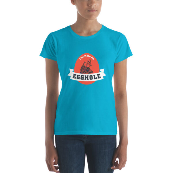 A woman wearing a turquoise t-shirt with the word " trouble " on it.