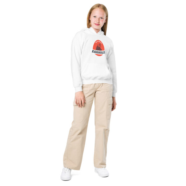 A girl standing in front of the camera wearing white pants and a sweatshirt.