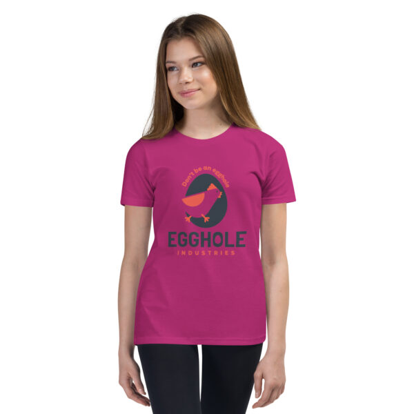 A girl wearing a pink t-shirt with an image of a dinosaur.