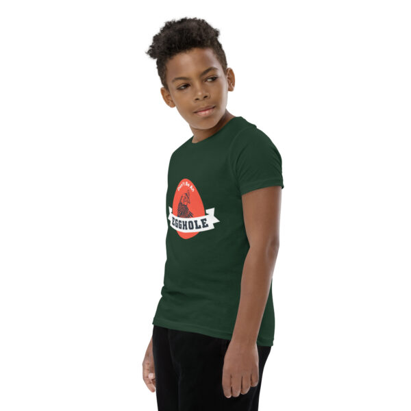 A young boy wearing a green t-shirt with an image of watermelon.