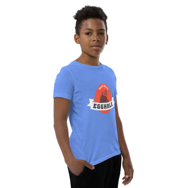 A boy wearing a blue t-shirt with the words " essential " on it.