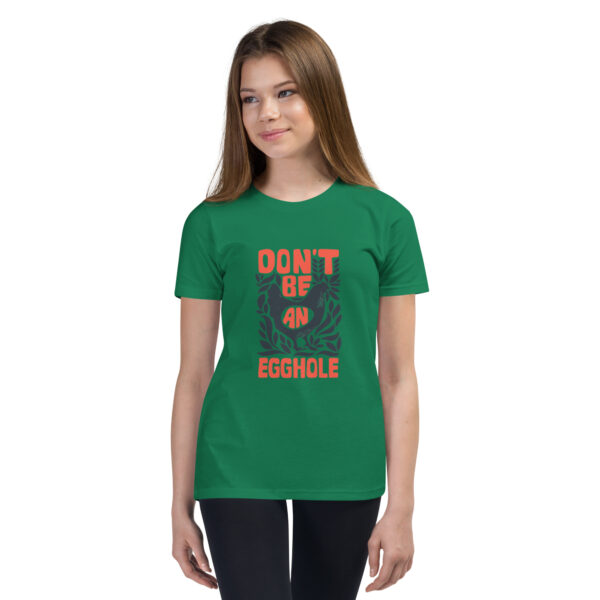 A girl wearing a green t-shirt with an orange and white design.