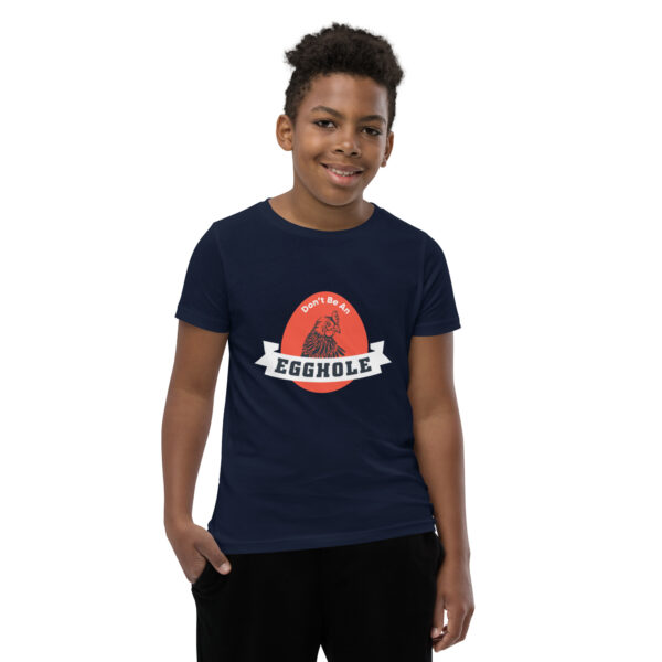 A kid wearing a t-shirt with the word assemble on it.