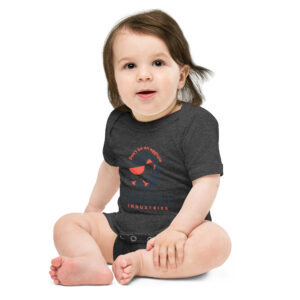 A baby sitting on the ground wearing a t-shirt