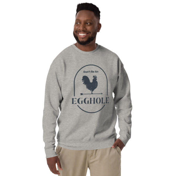 A man wearing a gray sweatshirt with an egg hole logo.