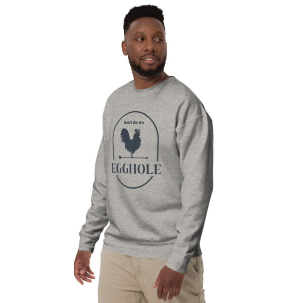 A man wearing a gray sweatshirt with an eagle on it.