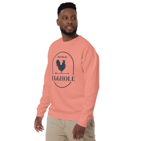 A man wearing an orange sweatshirt with a rooster on it.