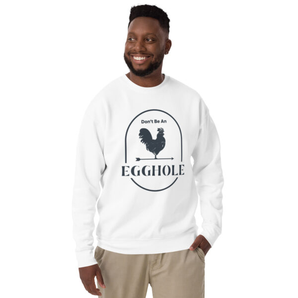 A man wearing a white sweatshirt with an egg hole logo.