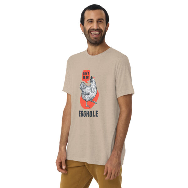 A man wearing a beige t-shirt with an image of a gorilla.