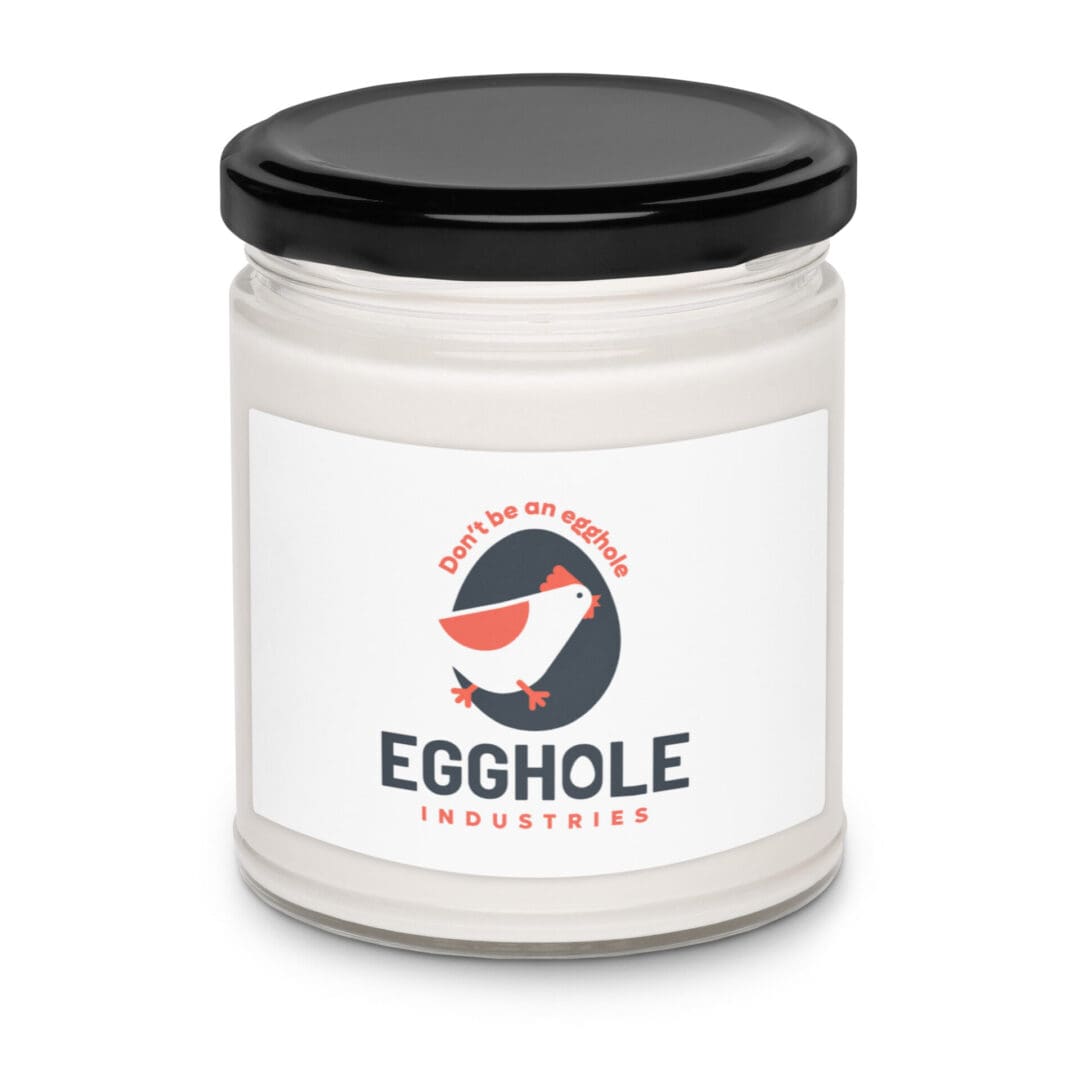 A white candle in a jar labeled 'Egghole' with a black lid.