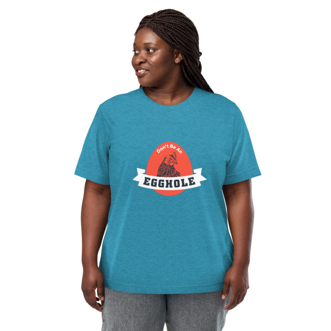 A smiling woman wearing a teal T-shirt with a colorful graphic design.