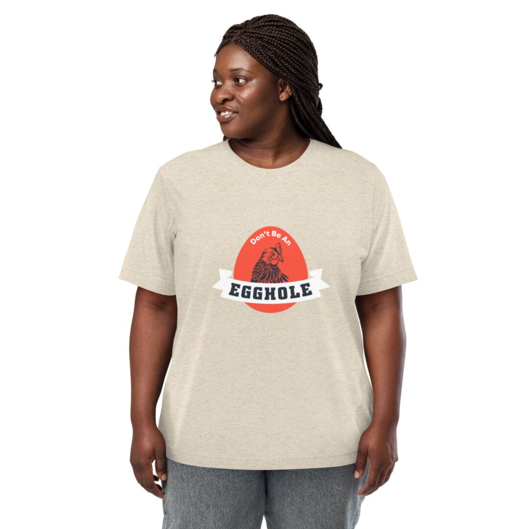 A smiling person wearing a beige t-shirt with a red and orange graphic.