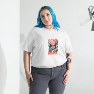 Woman with blue hair wearing a white graphic t-shirt and gray pants.