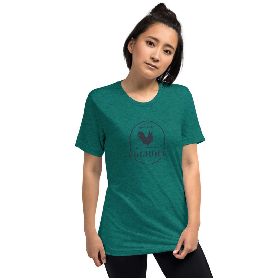 Young woman wearing a teal graphic t-shirt and black pants.