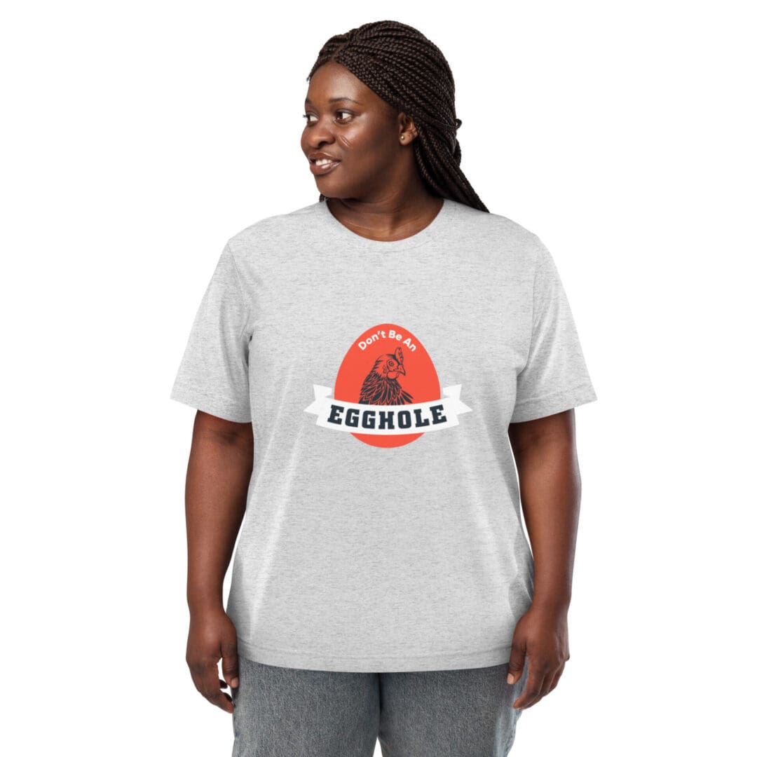 Smiling woman wearing a gray 'Assemble' graphic t-shirt and gray pants.